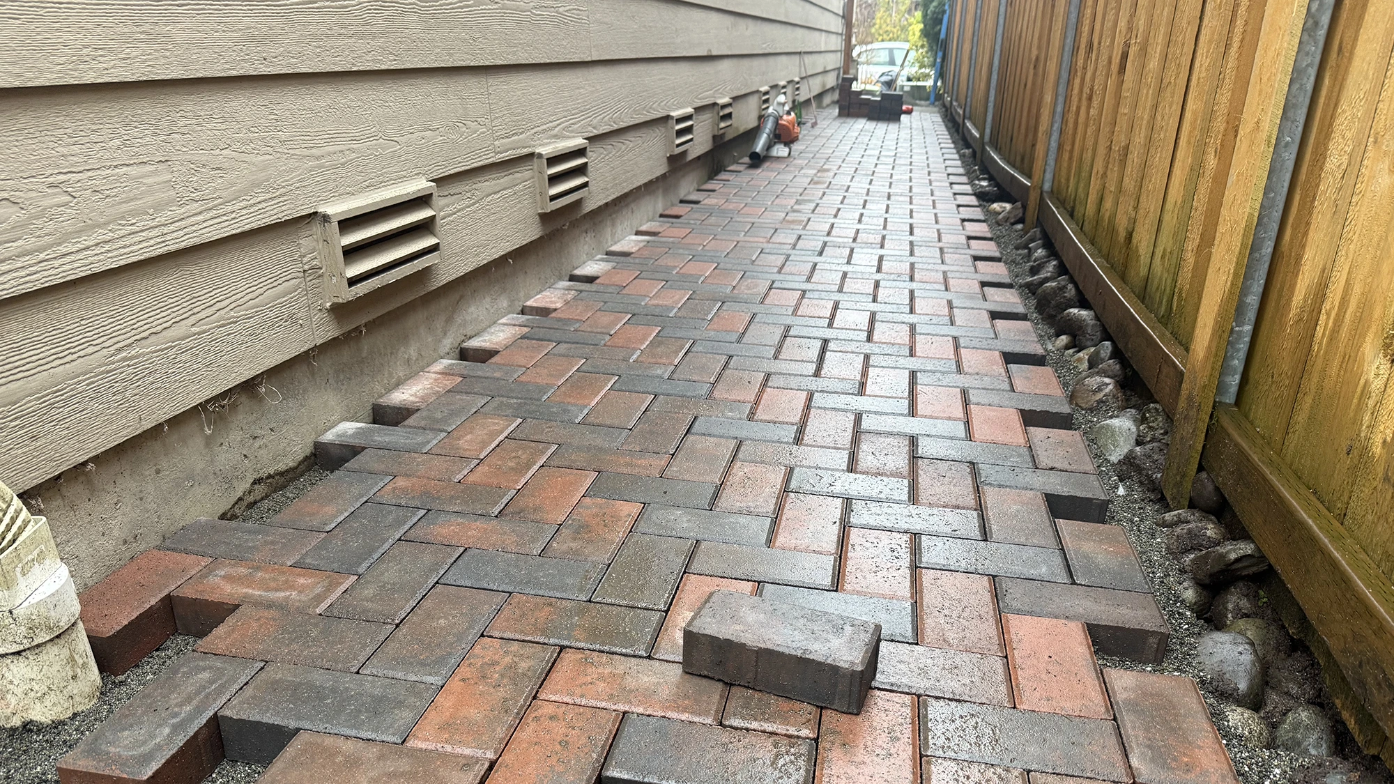 Red and charcoal herringbone paver walkway being installed in Sammamish, WA