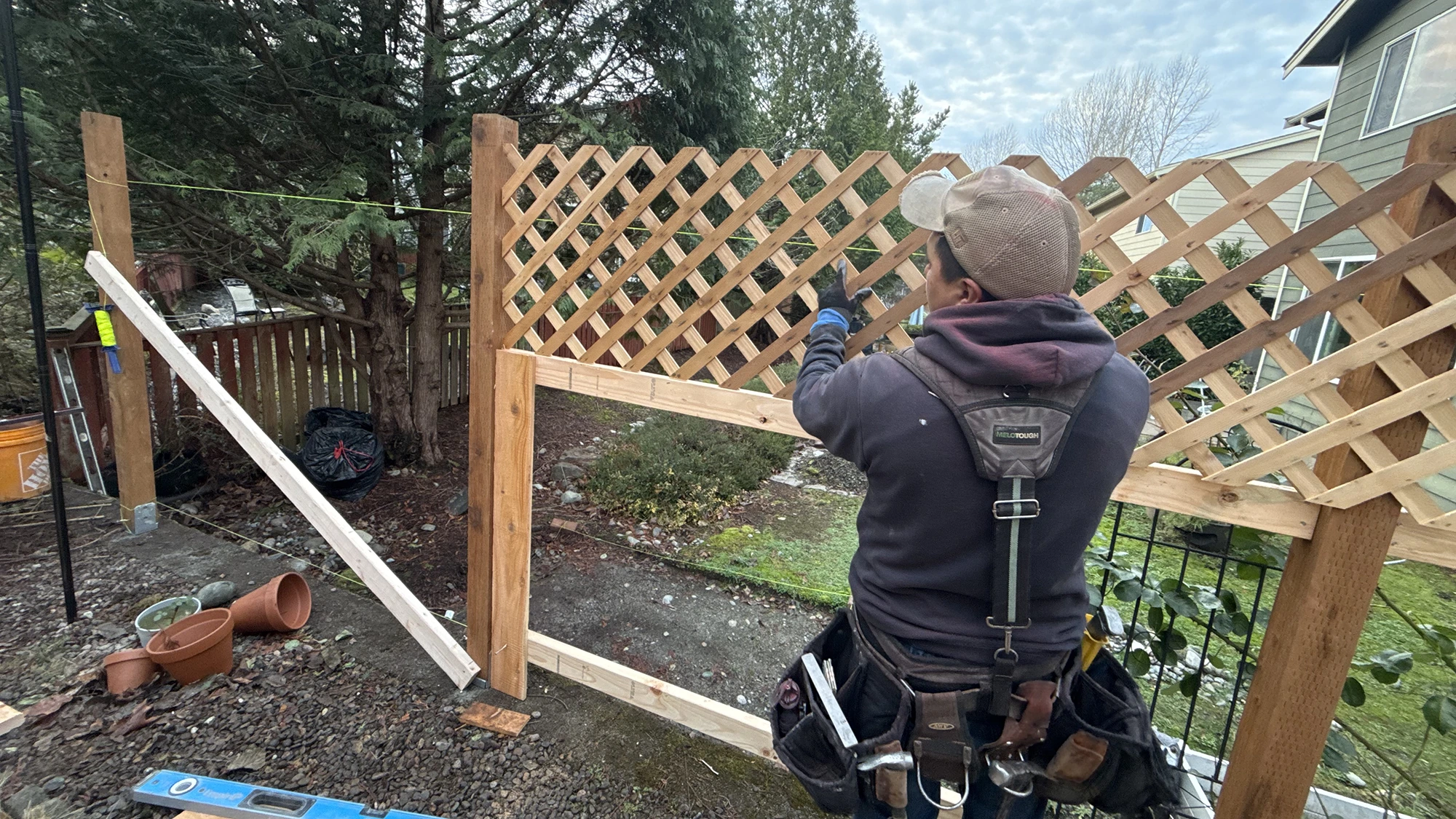 Installer fitting the cedar lattice top on a new privacy fence in Sammamish, WA