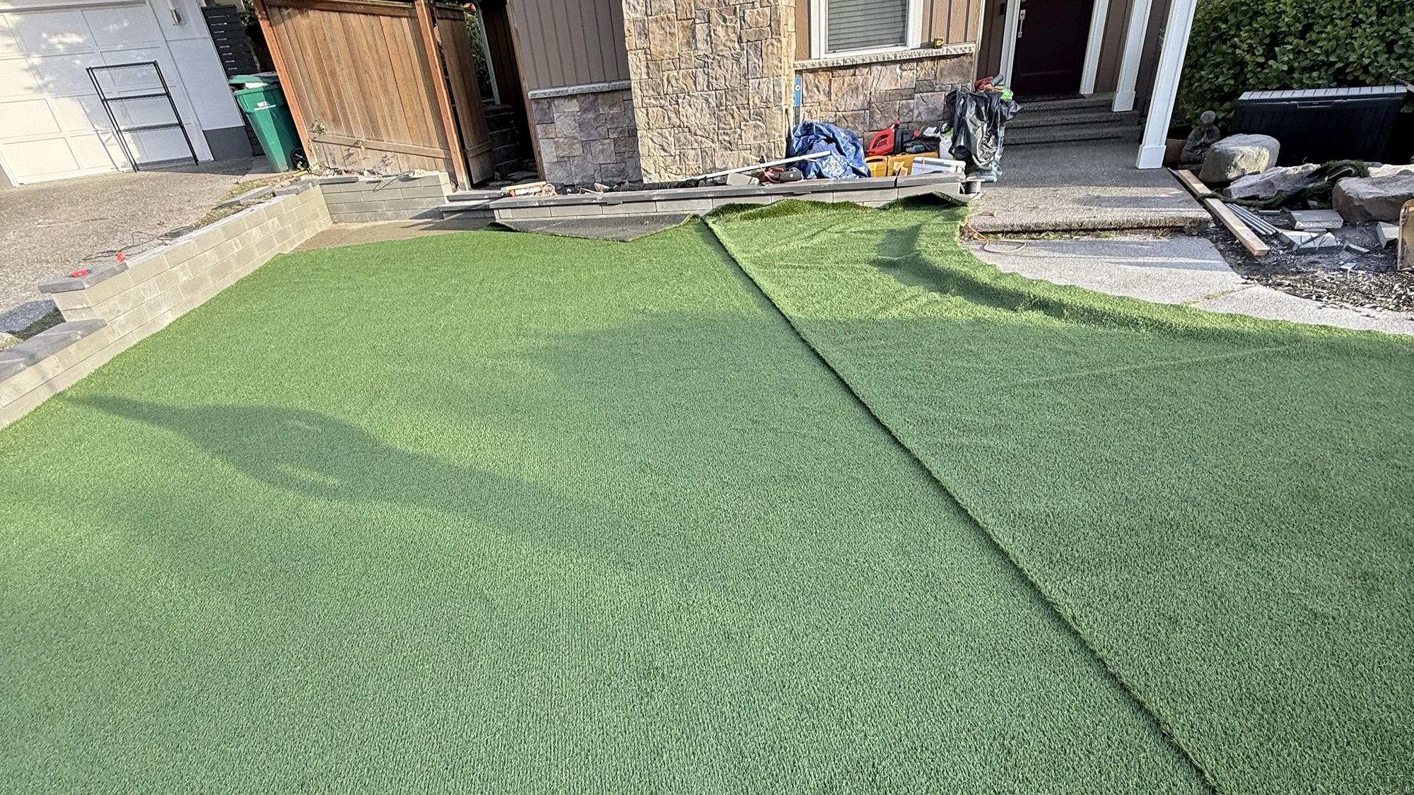 Rolling out artificial turf over the prepared base in Kirkland, WA