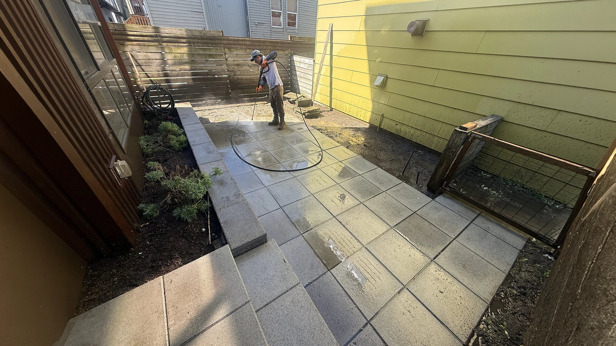 Pressure washing the existing slab patio and steps before the turf installation in Matthews Beach, Seattle