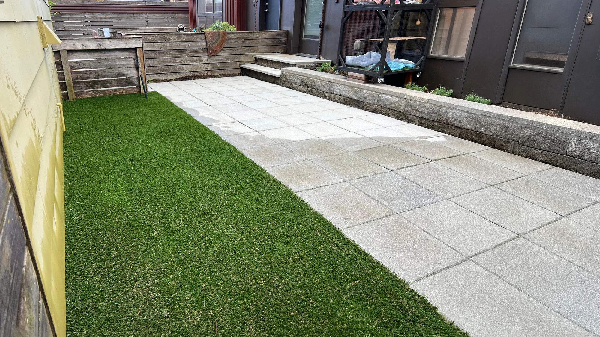 Finished artificial turf next to the cleaned patio in a Matthews Beach, Seattle backyard