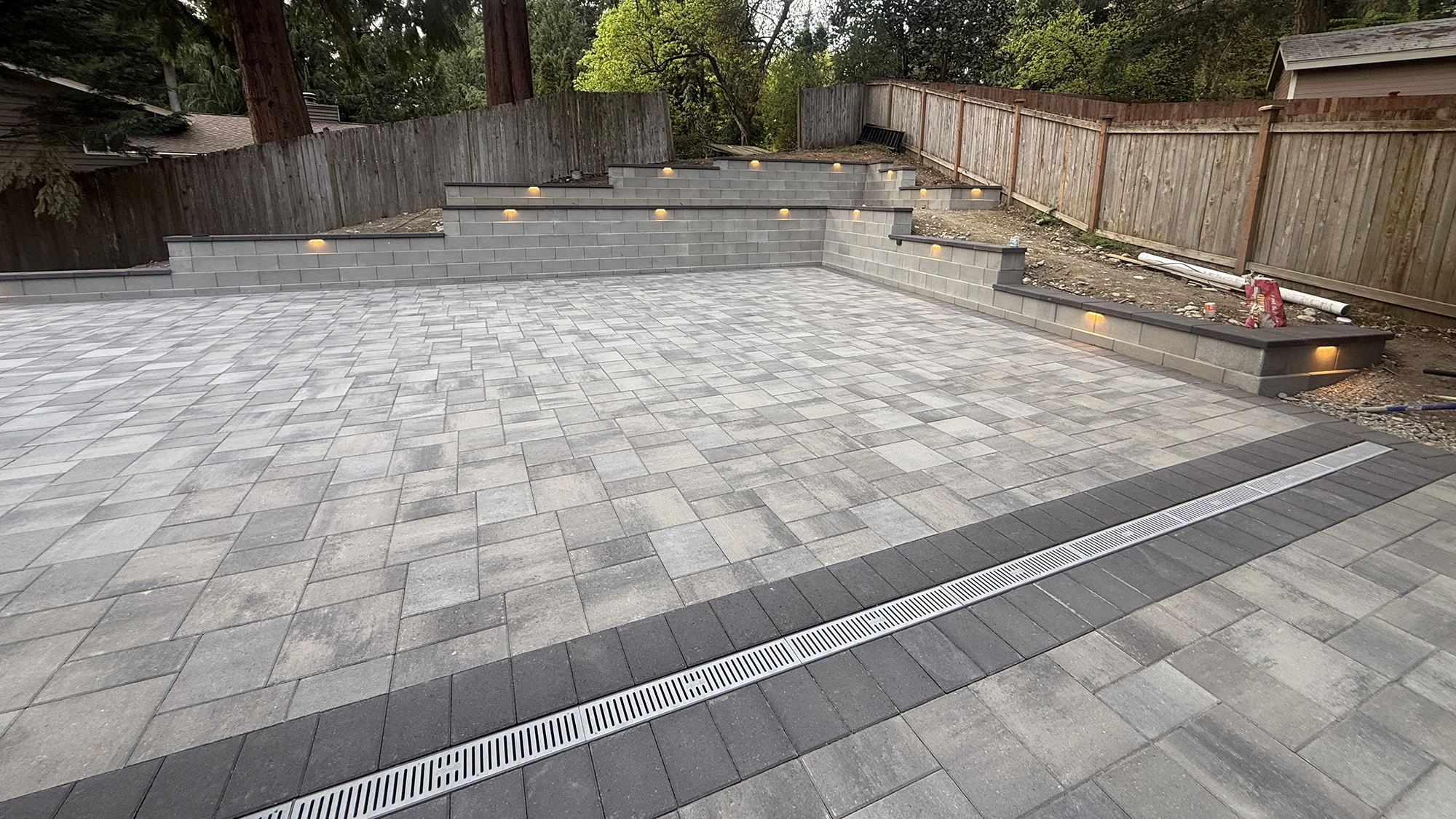 Finished paver patio with charcoal border and linear channel drain in Bothell, WA