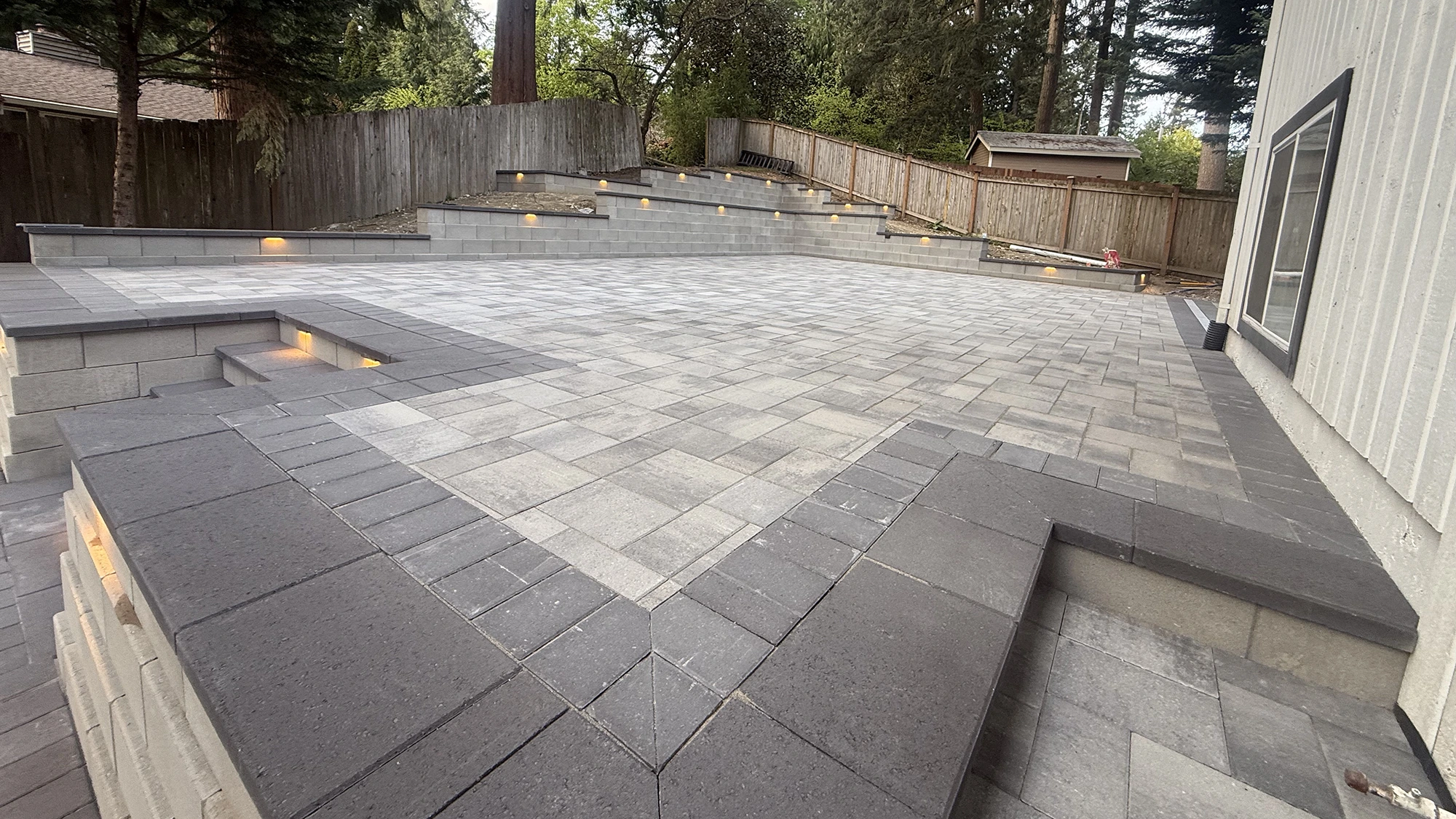 Block steps and retaining wall framing the paver patio in Bothell, WA