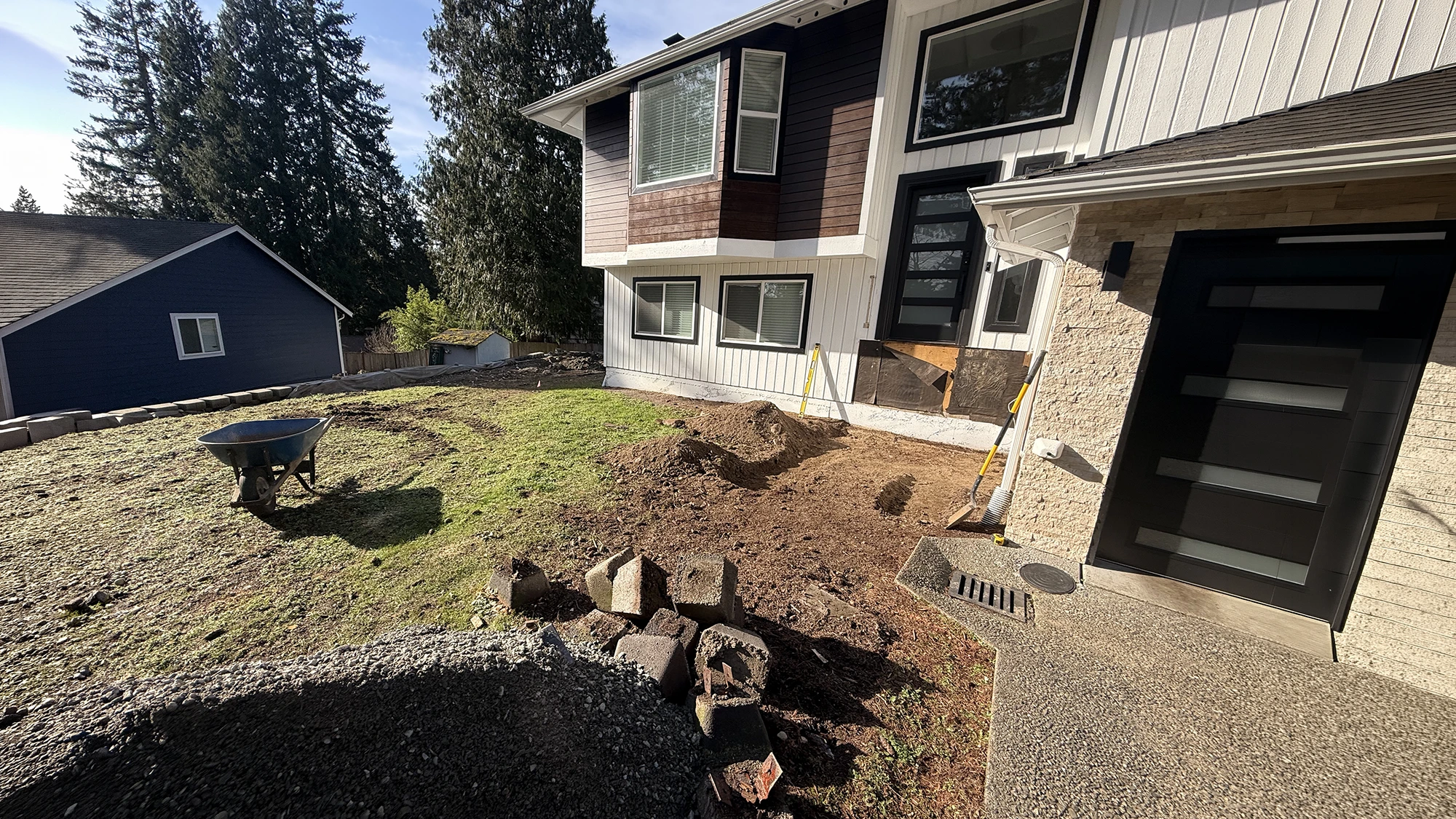 Bare front yard with an old block edge before the hardscape renovation in Bothell