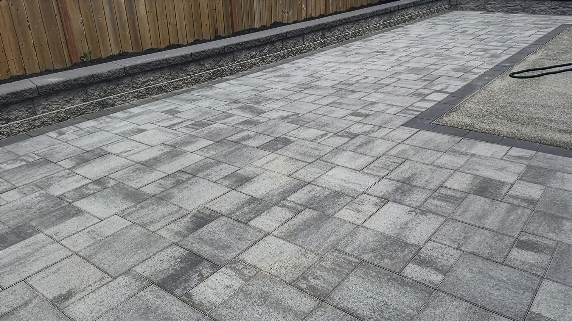 Gray blend paver patio along a capped block retaining wall in Mill Creek, WA