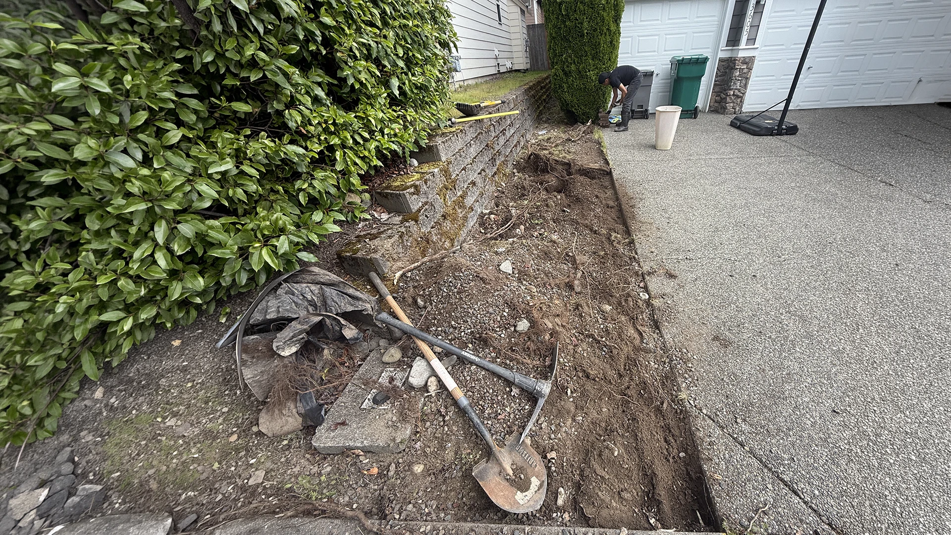 Excavating along the old block wall next to the driveway in Mill Creek, WA