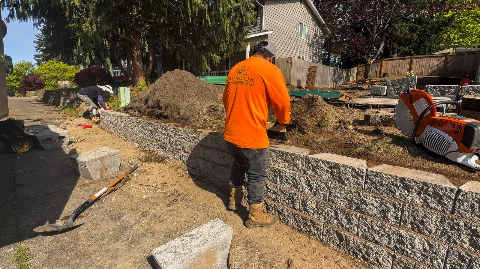 Installing and leveling split-face retaining wall blocks course by course in Federal Way, WA