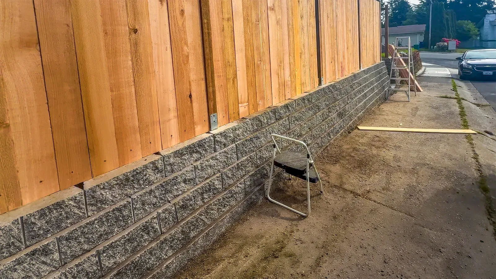 Fence posts anchored on the retaining wall cap with metal post bases in Federal Way, WA