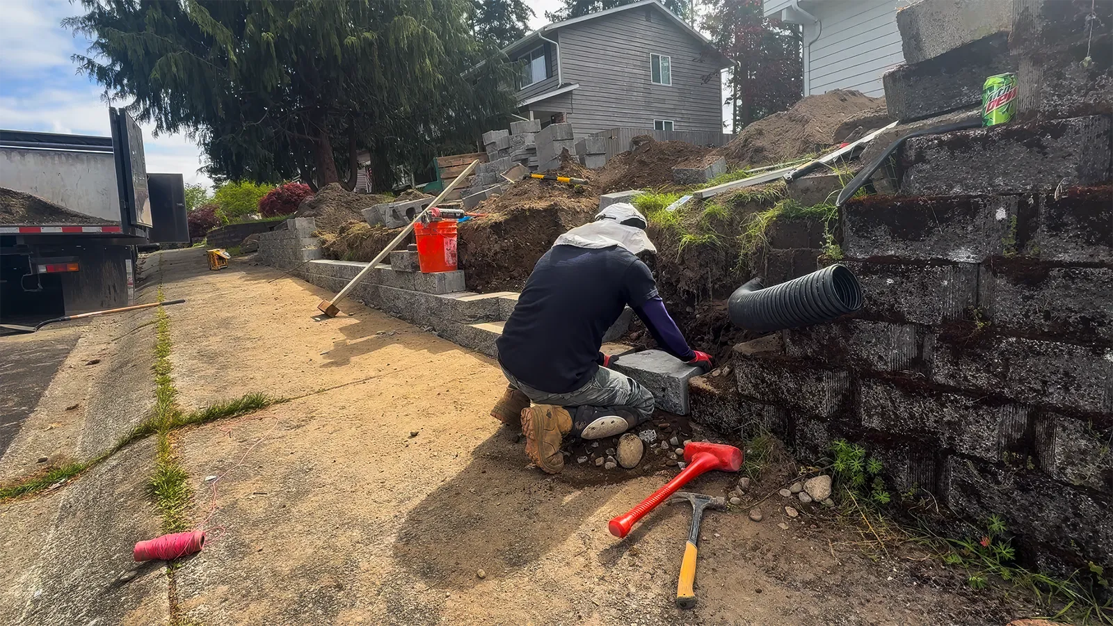 Laying the base course of the new retaining wall along the sidewalk in Federal Way, WA