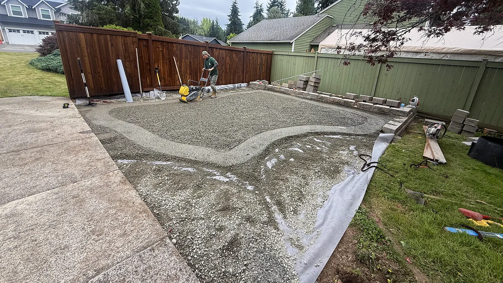 Compacting the gravel base for a curved paver patio in Duvall, WA