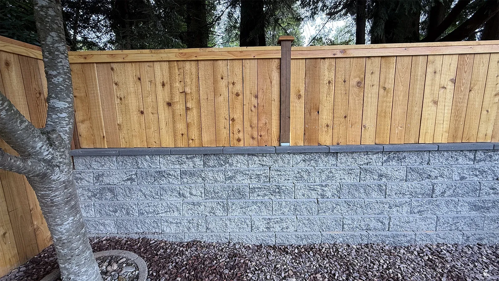 Cedar fence above a stone block retaining wall in Matthews Beach, Seattle