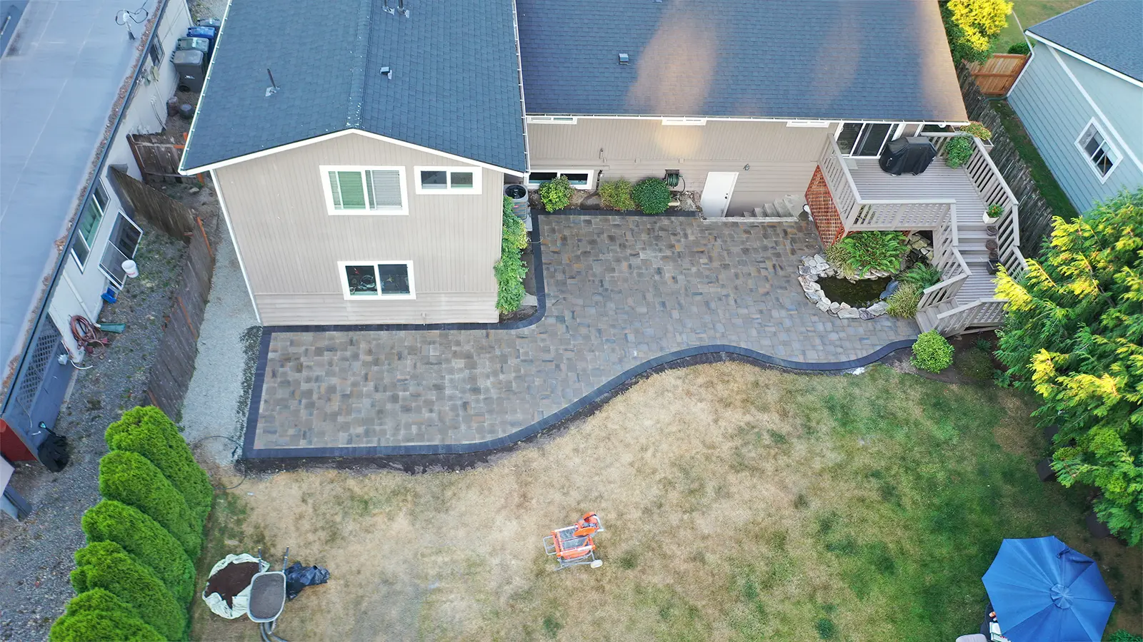 Aerial view of a completed L-shaped paver patio and walkway in Bothell, WA