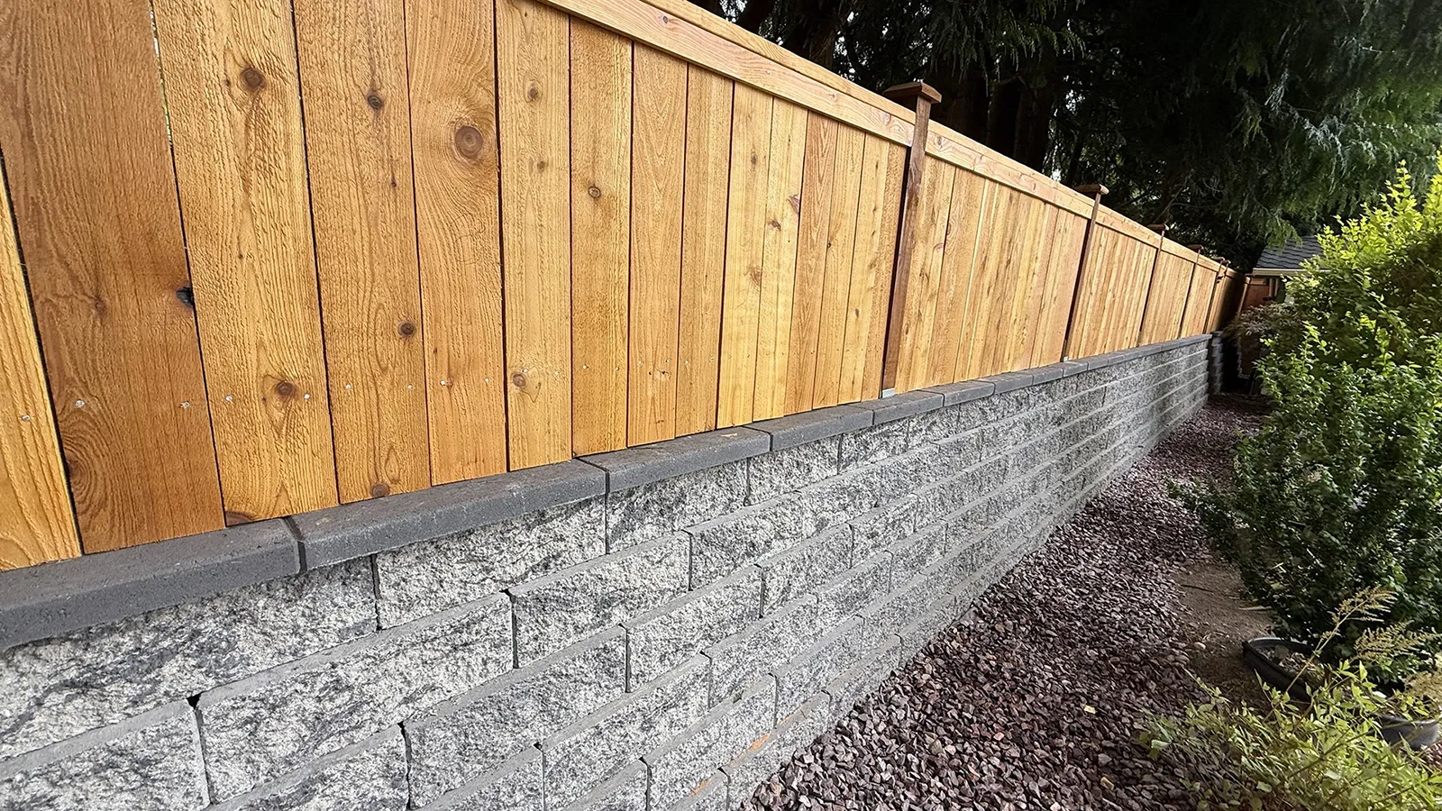 Completed retaining wall with cedar fence along a Seattle backyard
