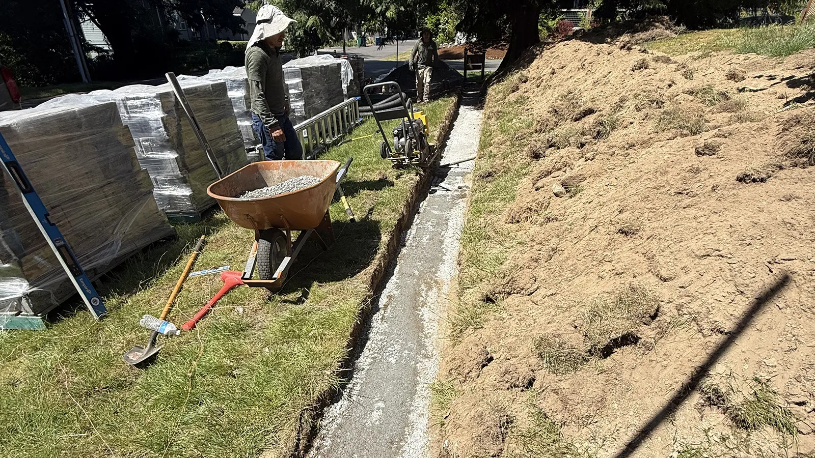 Compacting the gravel base for the retaining wall foundation in Seattle, WA
