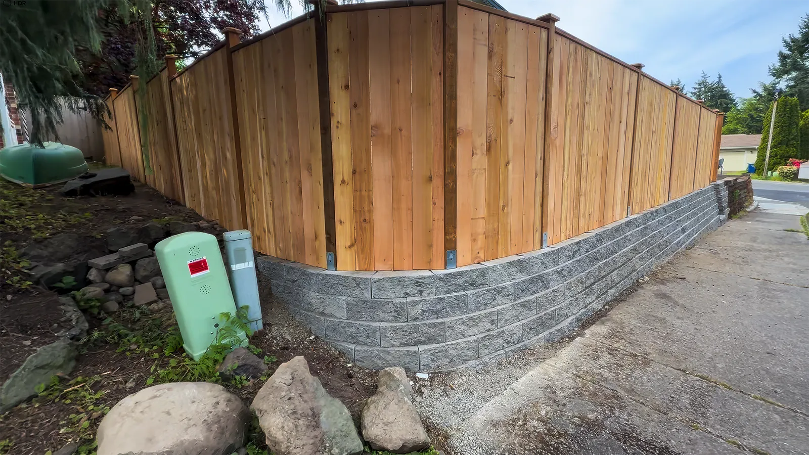 Custom concrete block retaining wall, block stairs and cedar privacy fence above a new lawn in Federal Way