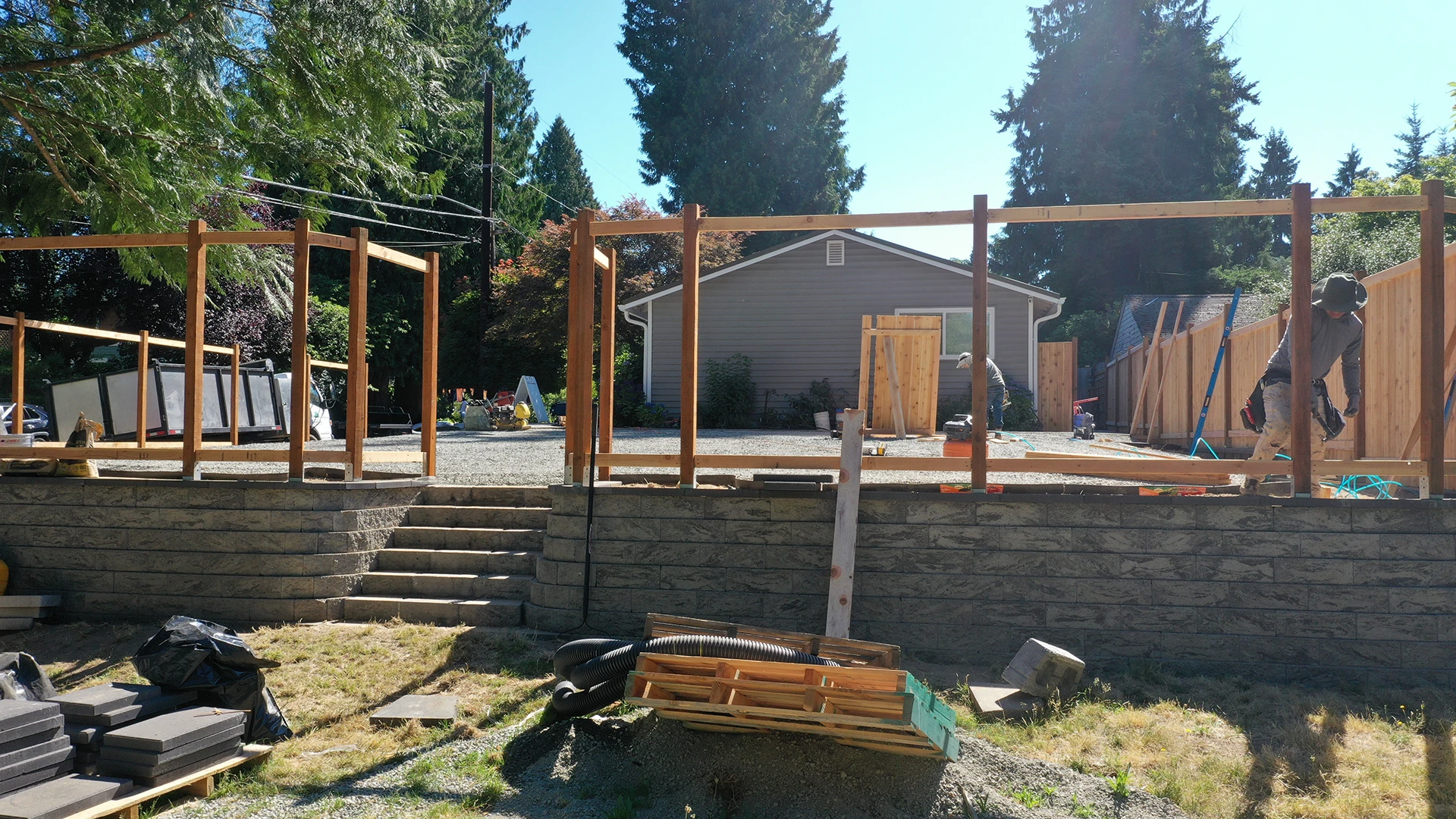 Cedar fence framing above a concrete block retaining wall with steps in Seattle