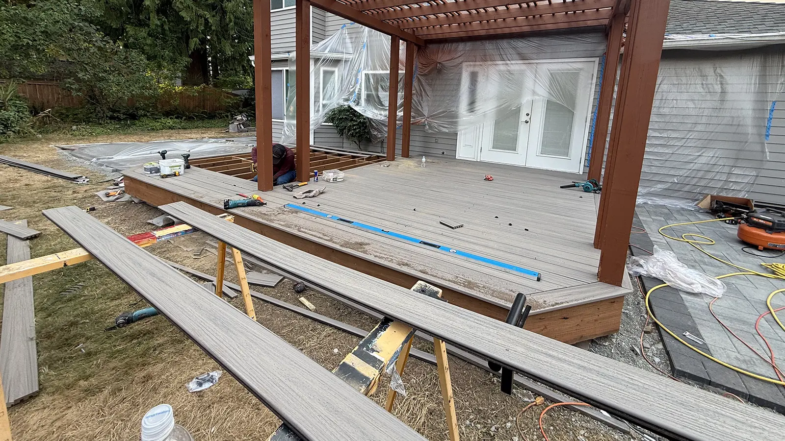 Composite decking boards being installed under the new pergola in Duvall, WA