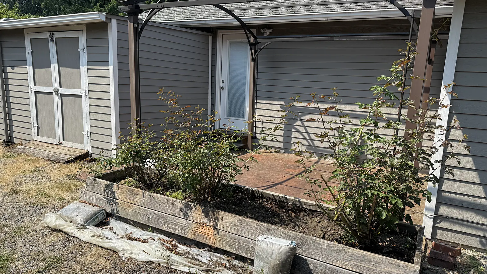 Old brick patio and wood planter before renovation in Duvall, WA