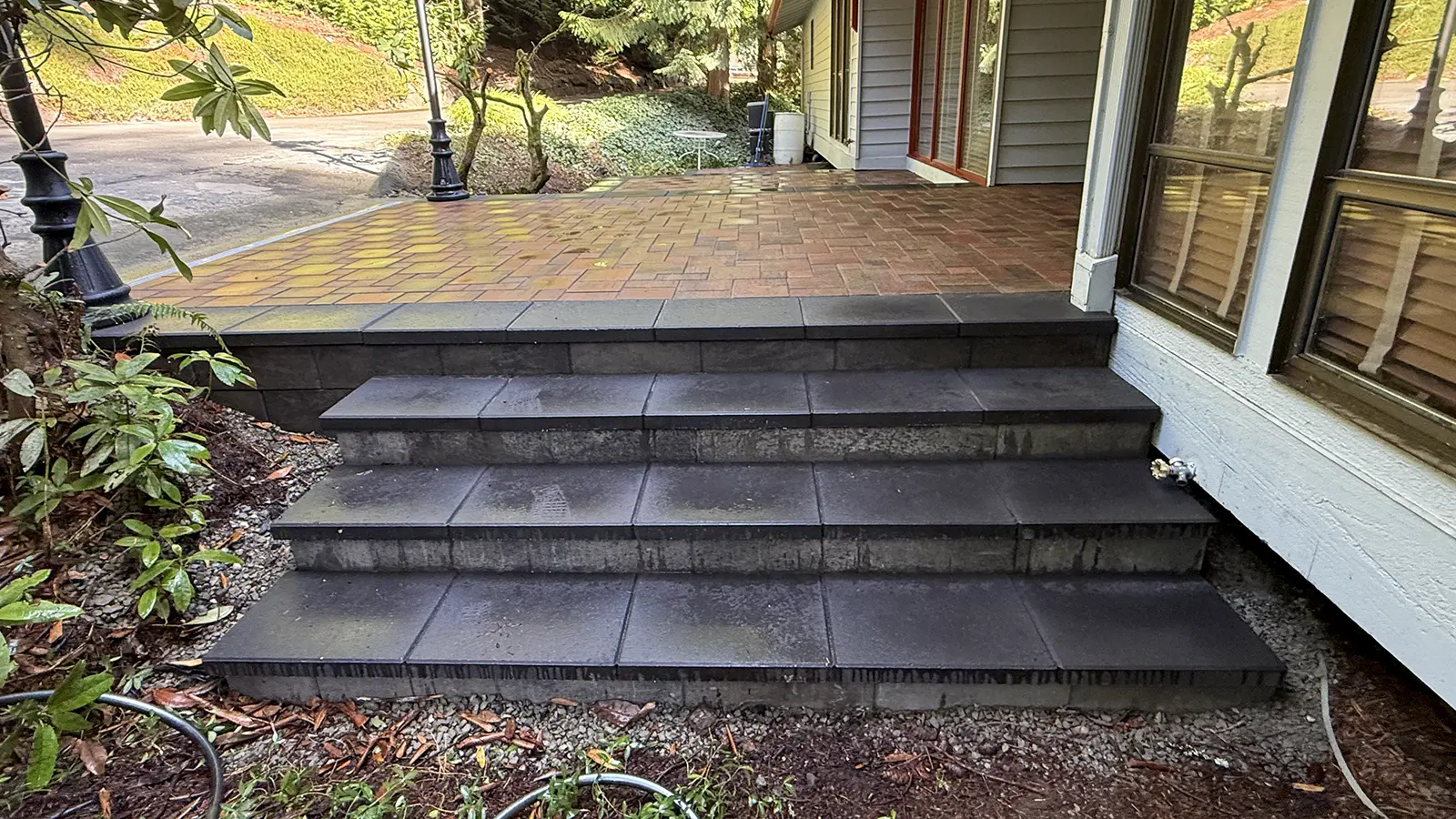 Finished charcoal paver steps leading up to a raised entry patio in Bothell, WA