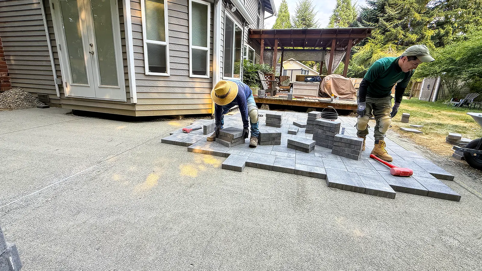 Crew laying large gray pavers on a screeded base in Duvall, WA
