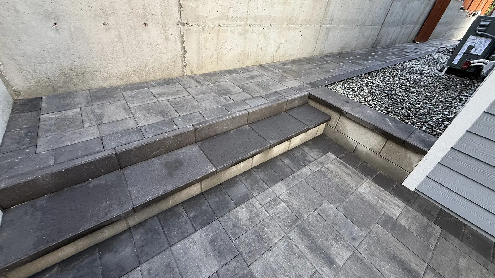 Detail of paver steps, raised landing and river rock bed in Bothell, WA