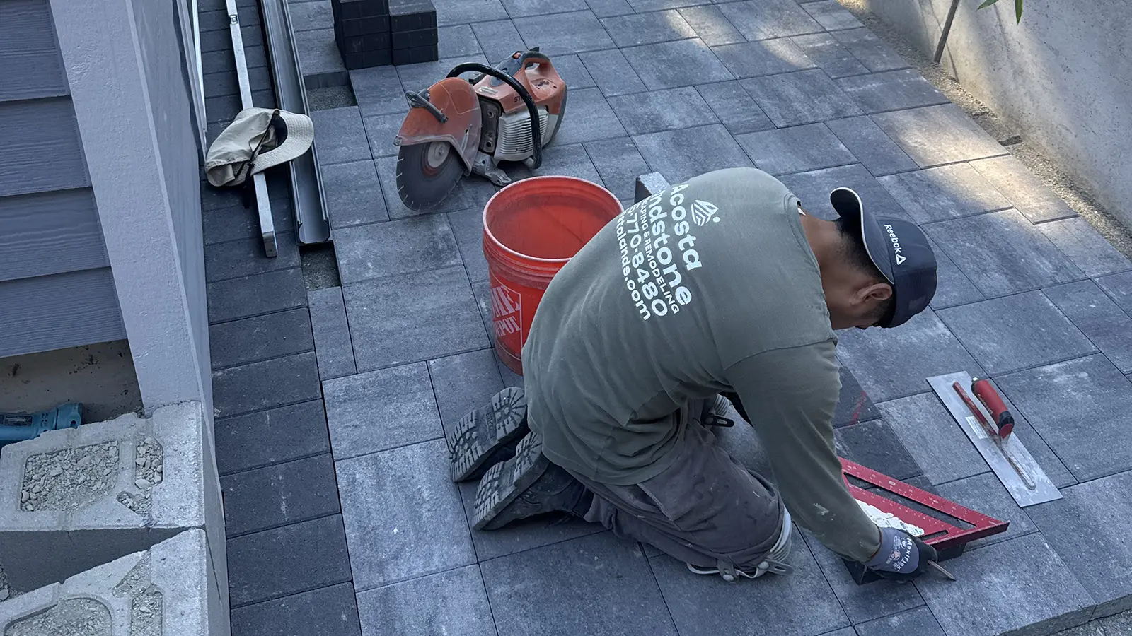 Acosta Landstone installer marking a precise paver cut in Bothell, WA