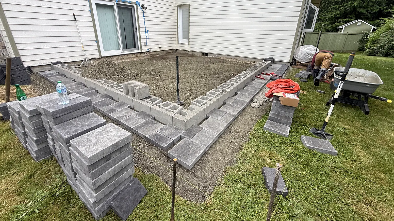 Block retaining wall and first paver step for a raised patio in Duvall, WA