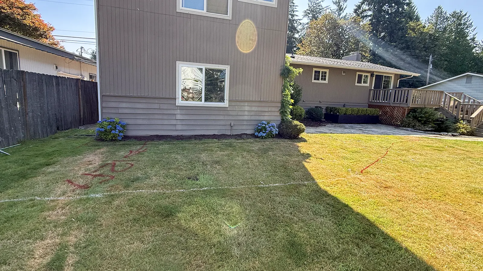 Paver patio layout marked with paint on the lawn beside the house in Bothell, WA