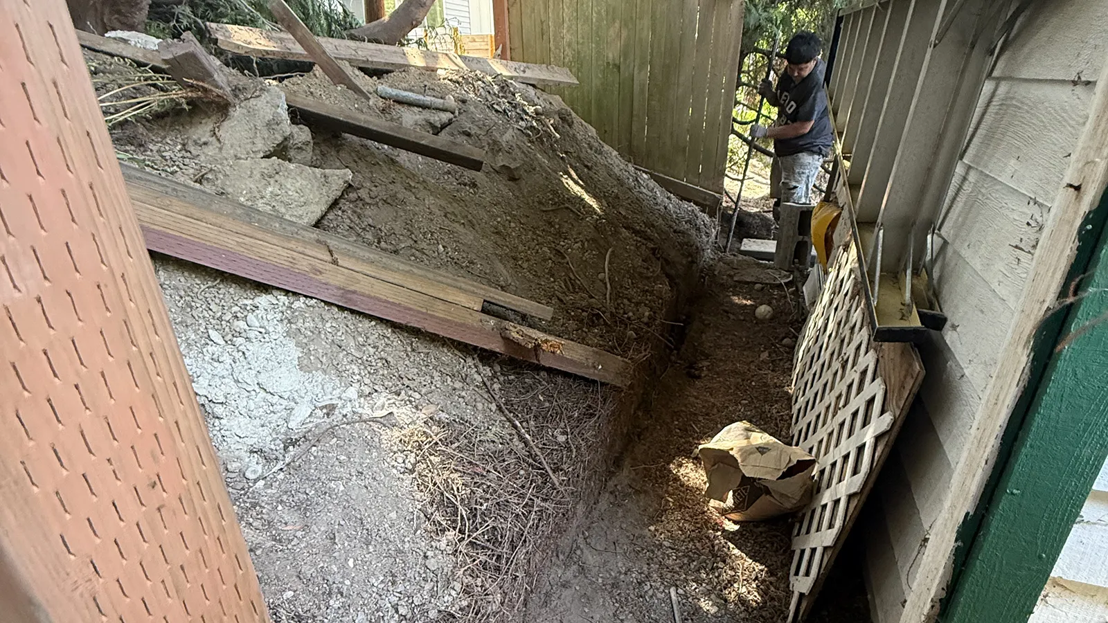 Excavating the slope and removing old timbers for a new retaining wall base in Seattle, WA