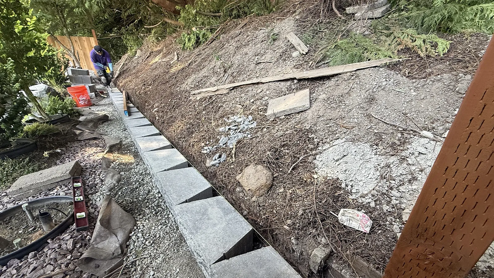 Leveling the first course of retaining wall blocks on a gravel base in Seattle, WA