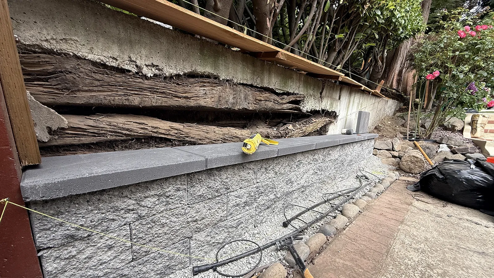 Old rotting timber retaining wall being replaced with a concrete block wall in Seattle, WA