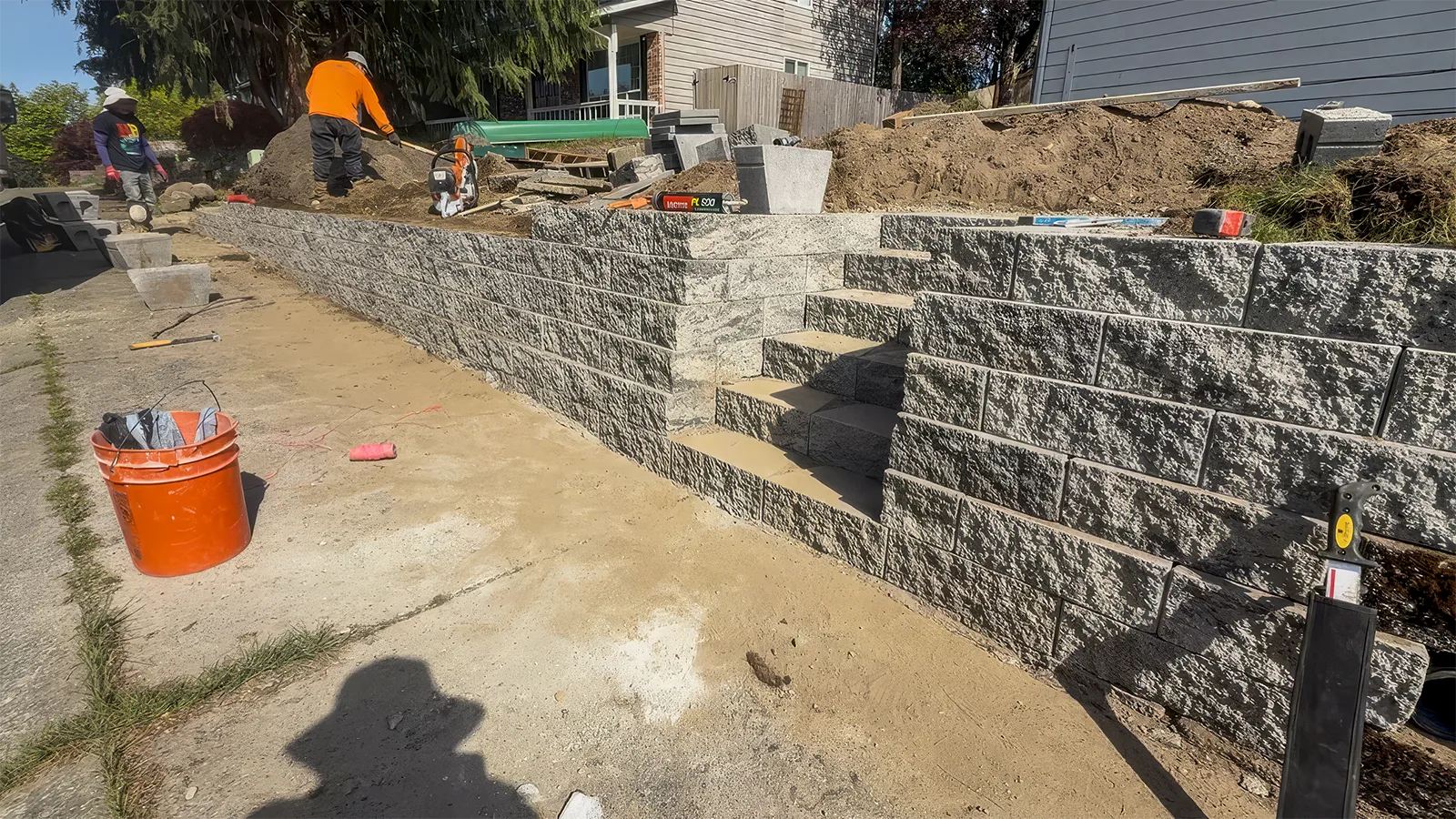 New retaining wall with custom block stairs and cedar fence posts in Federal Way, WA
